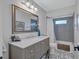 Bathroom with gray vanity, marble countertop, and patterned floor at 6609 Waterford Ln, Sarasota, FL 34238