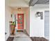 Inviting entryway with a modern orange door and tile flooring at 6609 Waterford Ln, Sarasota, FL 34238