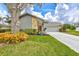 Mid-century modern home with gray exterior and mature tree at 6609 Waterford Ln, Sarasota, FL 34238