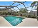 Refreshing screened pool surrounded by lush landscaping at 6609 Waterford Ln, Sarasota, FL 34238