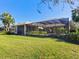 Back of house showcasing a screened patio and lush lawn at 7123 Beechmont Ter, Lakewood Ranch, FL 34202