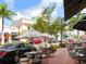 Outdoor cafe with tables and umbrellas in a plaza at 7123 Beechmont Ter, Lakewood Ranch, FL 34202