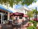 Outdoor cafe with umbrellas and tables, next to shops at 7123 Beechmont Ter, Lakewood Ranch, FL 34202