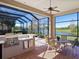 Covered outdoor kitchen with stainless steel appliances and seating area at 7123 Beechmont Ter, Lakewood Ranch, FL 34202