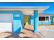 Exterior of waterfront home with bright blue walls and yellow door at 725 N Manasota Key Rd # A, Englewood, FL 34223