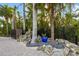 Landscaped entrance with a black metal gate surrounded by palm trees and river rock at 10204 46Th W Ave, Bradenton, FL 34210