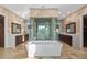 Modern bathroom with large soaking tub, dual vanities, and a central glass-enclosed shower at 10204 46Th W Ave, Bradenton, FL 34210