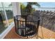 Outdoor spiral staircase with wooden deck, metal railing, and views of the water and palm trees at 10204 46Th W Ave, Bradenton, FL 34210