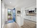 Bright entryway featuring a blue front door, tile flooring and a glimpse of the kitchen with white cabinetry at 1912 Harbourside Dr # 603, Longboat Key, FL 34228