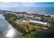 Aerial view showing condo building near beach and tennis courts at 3330 Gulf Of Mexico Dr # 205D, Longboat Key, FL 34228