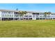 Exterior view of Longboat Arms building, showcasing landscaping and waterfront location at 3330 Gulf Of Mexico Dr # 205D, Longboat Key, FL 34228