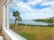 Stunning water view from large window, showcasing palm trees and waterfront at 3330 Gulf Of Mexico Dr # 205D, Longboat Key, FL 34228