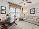 Bright home office features built-in desk, comfortable couch, and large window at 4925 Surfside Cir, Bradenton, FL 34211