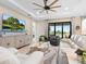 Living room features light sofas, a large TV, and access to a patio at 4925 Surfside Cir, Bradenton, FL 34211