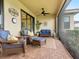 Relaxing screened porch with wicker furniture and ceiling fan at 4925 Surfside Cir, Bradenton, FL 34211