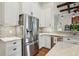 Modern white kitchen with stainless steel refrigerator and marble countertops at 609 Colonial Bay Dr, Nokomis, FL 34275