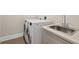 Laundry room with washer, dryer, and utility sink at 609 Colonial Bay Dr, Nokomis, FL 34275