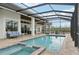 Large screened-in pool and spa with a view of the surrounding landscape at 609 Colonial Bay Dr, Nokomis, FL 34275