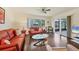 Living room with orange couches, wood floors, and sliding glass doors at 6100 Green View Dr # 145, Sarasota, FL 34231