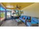 Bright screened porch featuring wicker furniture and ceiling fan at 6100 Greenview Dr # 145, Sarasota, FL 34231