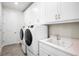 Laundry room with white cabinets, a utility sink and washer/dryer at 9153 Radiant Cir, Sarasota, FL 34241