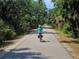 Person biking down a scenic path with lush foliage at 988 Blvd Of The Arts # 915, Sarasota, FL 34236