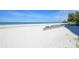 Beautiful white sandy beach with turquoise water and green lounge chairs available for residents and guests at 19 Whispering Sands Dr # 1204, Sarasota, FL 34242