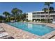 Relaxing community pool with surrounding lounge chairs and a building at 19 Whispering Sands Dr # 1204, Sarasota, FL 34242