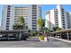 Two-building complex with covered parking and tropical landscaping at 19 Whispering Sands Dr # 1204, Sarasota, FL 34242