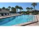 Refreshing community pool with lounge chairs and palm trees at 19 Whispering Sands Dr # 1204, Sarasota, FL 34242