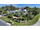 Aerial view of a house with a white exterior, lush landscaping, and a white fence at 2402 Palmetto St, Nokomis, FL 34275