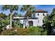 White house with red tile roof, tropical landscaping, and palm trees at 2402 Palmetto St, Nokomis, FL 34275
