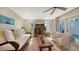 Relaxing living area featuring a sofa, armchairs, and a large TV at 2402 Palmetto St, Nokomis, FL 34275