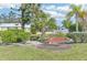 Relaxing backyard oasis with a bench, lush landscaping, and palm trees at 5891 Tidewood Ave # 1, Sarasota, FL 34231