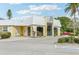 Building exterior featuring a yellow facade, large windows, and ample parking at 5891 Tidewood Ave # 1, Sarasota, FL 34231