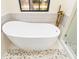 Elegant freestanding bathtub with pebble tile floor in a modern bathroom at 6305 Royal Tern Cir, Lakewood Ranch, FL 34202