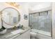Stylish bathroom with a granite countertop, a round mirror and a walk-in shower at 6305 Royal Tern Cir, Lakewood Ranch, FL 34202