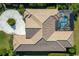 Bird's-eye view of a home with tile roof, pool, and circular driveway at 7112 Saint Johns Way, University Park, FL 34201