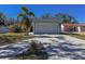 Exterior view of house with palm tree and brick driveway at 8224 Country Oaks Ct, Sarasota, FL 34243