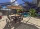 Relaxing patio with table and chairs, adjacent to the pool at 8224 Country Oaks Ct, Sarasota, FL 34243