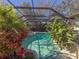 Inviting pool area with screened enclosure, lush landscaping, and patio furniture at 8224 Country Oaks Ct, Sarasota, FL 34243