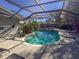 Inviting pool area with screened enclosure, lush landscaping, and patio furniture at 8224 Country Oaks Ct, Sarasota, FL 34243