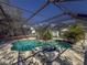 Inviting pool area with screened enclosure, lush landscaping, and patio furniture at 8224 Country Oaks Ct, Sarasota, FL 34243