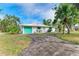 White house with teal garage door and palm trees at 3029 Homasassa Rd, Sarasota, FL 34239