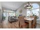 Bright dining area with a large table and wicker chairs, hardwood floors, and a view to the living room at 502 Woodstork Cir, Bradenton, FL 34209