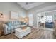 Living room features a striped sofa, white coffee table, and access to a screened porch at 502 Woodstork Cir, Bradenton, FL 34209