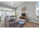 Open living room with gray sectional sofa, wood floors, and access to a screened porch at 502 Woodstork Cir, Bradenton, FL 34209