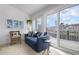 Bright sunroom with blue couch, wicker chair, and access to a balcony overlooking the water at 502 Woodstork Cir, Bradenton, FL 34209