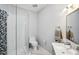 Modern bathroom with glass shower, gray mosaic tile, and floating vanity at 5159 Oxford Dr, Sarasota, FL 34242