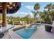 Inviting outdoor pool area with lounge chairs, lush landscaping, and a tiki umbrella at 5159 Oxford Dr, Sarasota, FL 34242